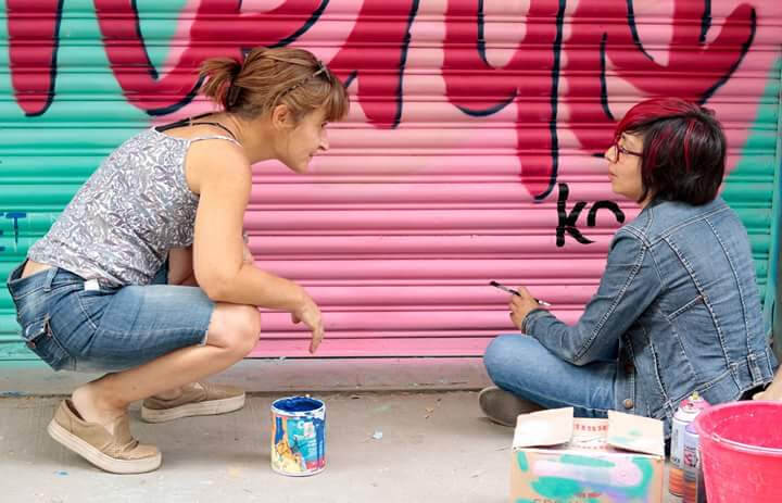 Ale Carughi trabaja junto a una artista en un Mural