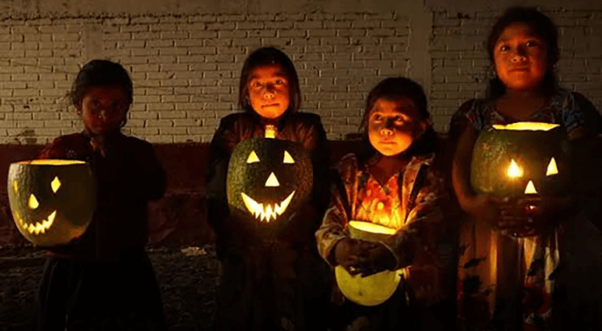 Niñas pidiendo calaverita con chilacayote con vela. 